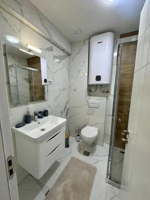 a white bathroom with a sink and a toilet at Diamond apartment in Podgorica