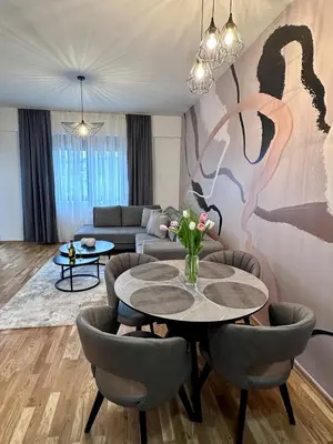 a living room with a table and chairs and a couch at Diamond apartment in Podgorica