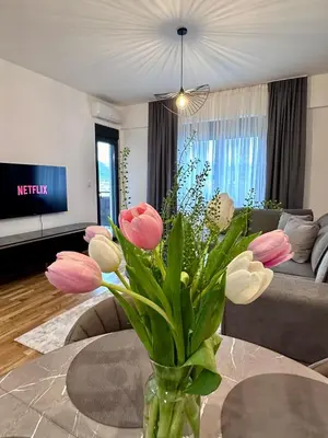 a vase with flowers on a table in a living room at Diamond apartment in Podgorica