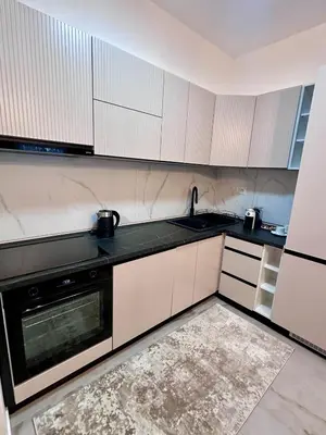 a kitchen with white cabinets and a black dishwasher at Diamond apartment in Podgorica