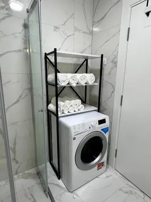 a washing machine in a bathroom next to a shower at Diamond apartment in Podgorica
