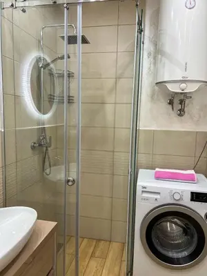 a bathroom with a washing machine and a sink at Luxury apartment with garage in Old bakery in Budva