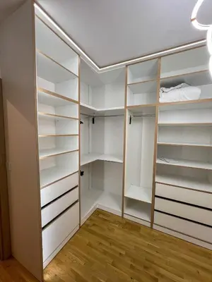 a walk in closet with white cabinets and wood floors at Luxury apartment with garage in Old bakery in Budva