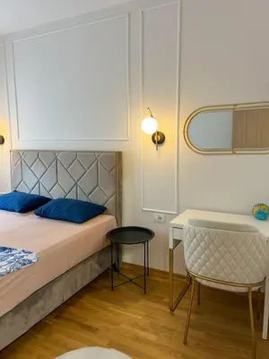 a bedroom with a bed and a table and a chair at Luxury apartment with garage in Old bakery in Budva