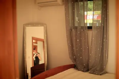 a person taking a picture of a bed in front of a mirror at Mountain View Villa in Budva