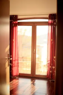 a large glass door with red curtains in a room at Mountain View Villa in Budva