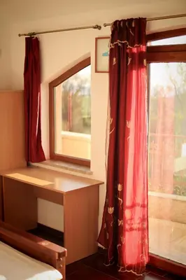 a bedroom with a window and a red curtain at Mountain View Villa in Budva