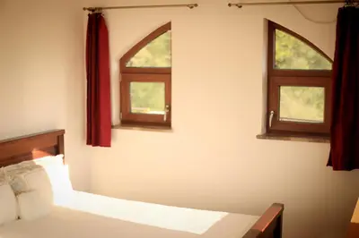 a bedroom with two windows and a bed at Mountain View Villa in Budva