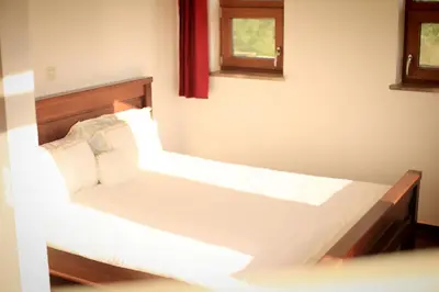 a bedroom with two beds with white sheets and a window at Mountain View Villa in Budva
