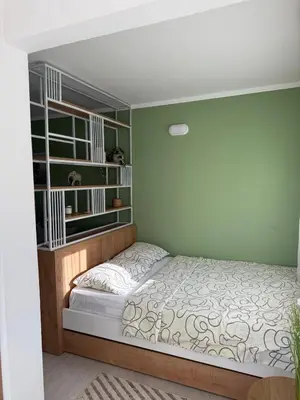 a bedroom with a bed and book shelves at Sanja apartman in Bar