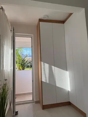 a large glass closet in a room with a door at Sanja apartman in Bar