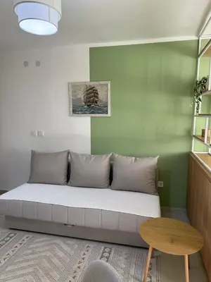 a couch sitting in a room with a table at Sanja apartman in Bar