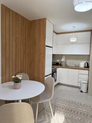 a small kitchen with a white table and chairs at Sanja apartman in Bar