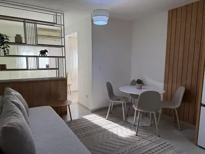 a living room with a couch and a table and chairs at Sanja apartman in Bar