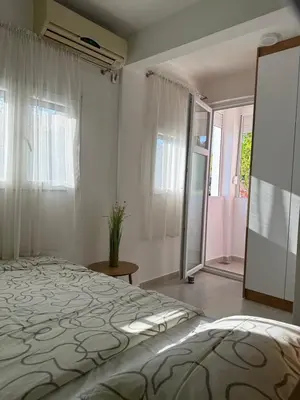 a bedroom with a bed and a large window at Sanja apartman in Bar