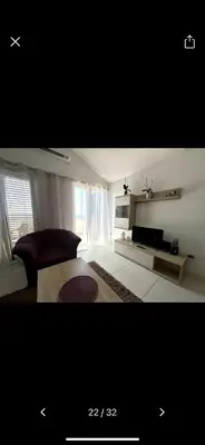 a white living room with a couch and a tv at Njaro del Mar 17 in Petrovac na Moru