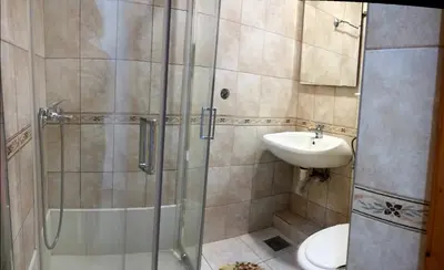 a bathroom with a shower and a toilet and a sink at Guest House Vila Bak in Budva