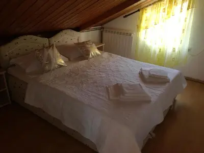 a bedroom with a white bed with towels on it at Guest House Vila Bak in Budva