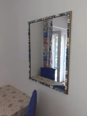 a mirror hanging on a wall in a bedroom at Guest House Vila Bak in Budva