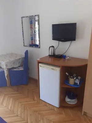a room with a desk and a tv and a table at Guest House Vila Bak in Budva