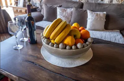 a bowl of fruit on a table with a bottle of wine at Montenegro Rustic House II in Bjeloši
