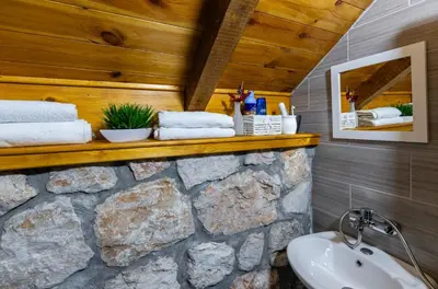 a bathroom with a stone wall and a sink at Montenegro Rustic House II in Bjeloši