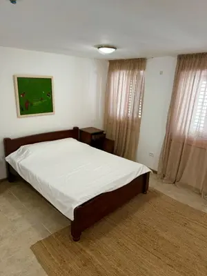 a bedroom with a large bed with white sheets at Apartman Kaprize in Budva