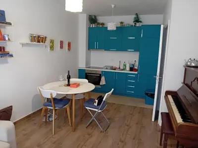 a kitchen with blue cabinets and a table and a piano at Piano Seaside in Ulcinj