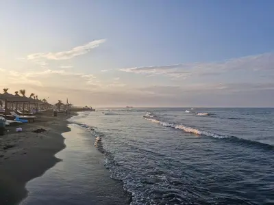 a beach with a group of umbrellas and the ocean at Piano Seaside in Ulcinj