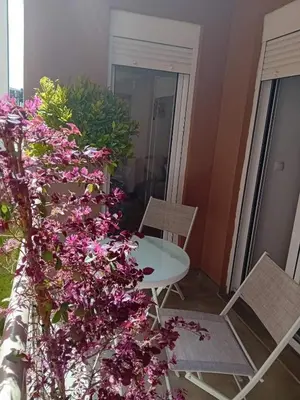 a table and chairs in a room with purple flowers at Piano Seaside in Ulcinj