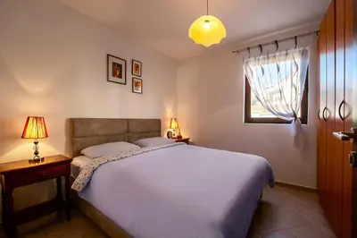 a bedroom with a large bed and a window at Bozovic Apartmani in Budva