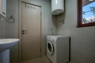 a bathroom with a washing machine and a sink at Bozovic Apartmani in Budva