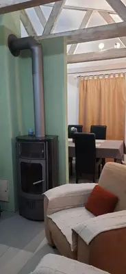 a living room with a fireplace and a couch and a table at Zlatna Guest House in Škaljari