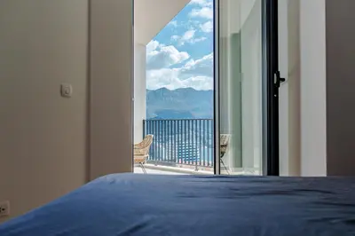 a bedroom with a bed and a view of the mountains at Sunshine Appartement Budva in Becici