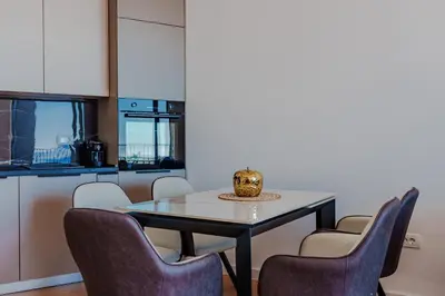 a dining room with a table and chairs at Sunshine Appartement Budva in Becici