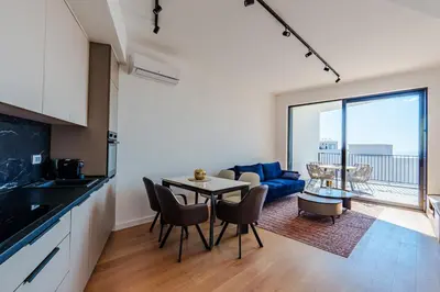 a kitchen and living room with a table and chairs at Sunshine Appartement Budva in Becici