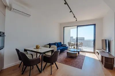 a living room with a table and a blue couch at Sunshine Appartement Budva in Becici