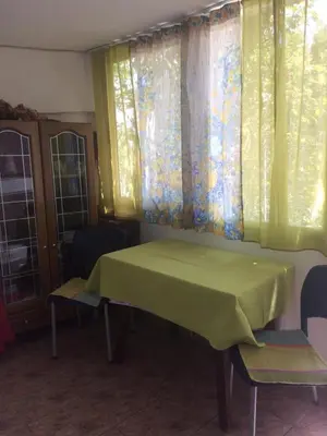 a green table and chairs in a room with windows at Zagradge I.N. apartments in Sutomore
