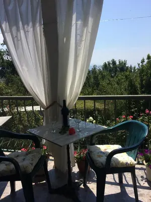 a table with two chairs and a bottle of wine at Zagradge I.N. apartments in Sutomore