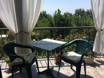 two chairs and a table on a balcony at Zagradge I.N. apartments in Sutomore