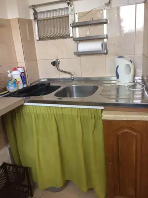 a kitchen sink with a green towel on the counter at Zagradge I.N. apartments in Sutomore