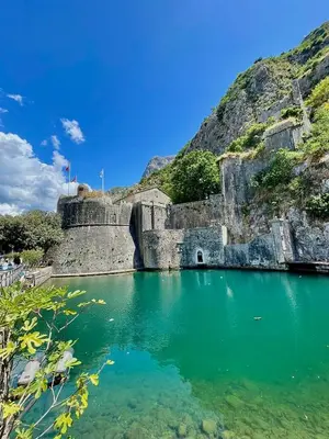 a pool of emerald green water next to a mountain at Kotor Old Town Cozy Escape in Kotor