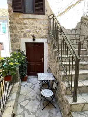 a stone stairway with a table and a door at Kotor Old Town Cozy Escape in Kotor