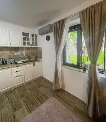 a kitchen with white cabinets and a window and a sink at Kotor Old Town Cozy Escape in Kotor