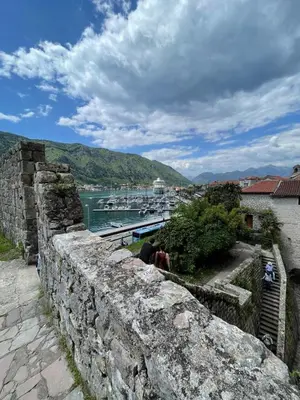 a group of people sitting on a wall looking over the water at Kotor Old Town Cozy Escape in Kotor