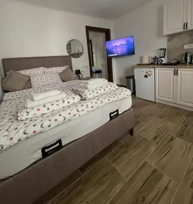 a bedroom with a large bed and a kitchen at Kotor Old Town Cozy Escape in Kotor