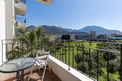 a balcony with a table and a view of the mountains at Apartment San Riviera in Bar