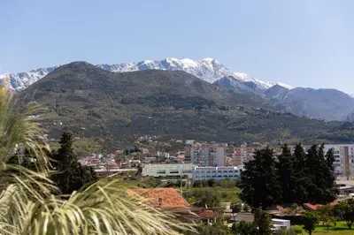 a city with snow capped mountains in the background at Apartment San Riviera in Bar