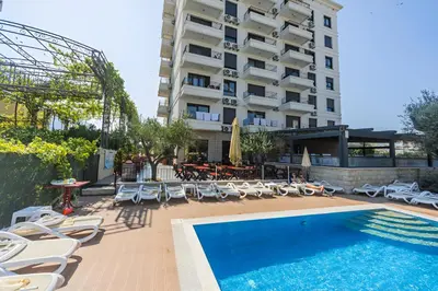 a hotel with a swimming pool and chairs and a building at Apartment San Riviera in Bar