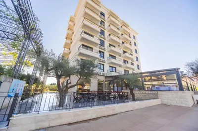 a building with tables and chairs in front of it at Apartment San Riviera in Bar